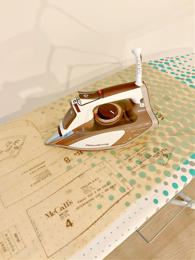 an iron while pressing a paper pattern on a regular ironing board