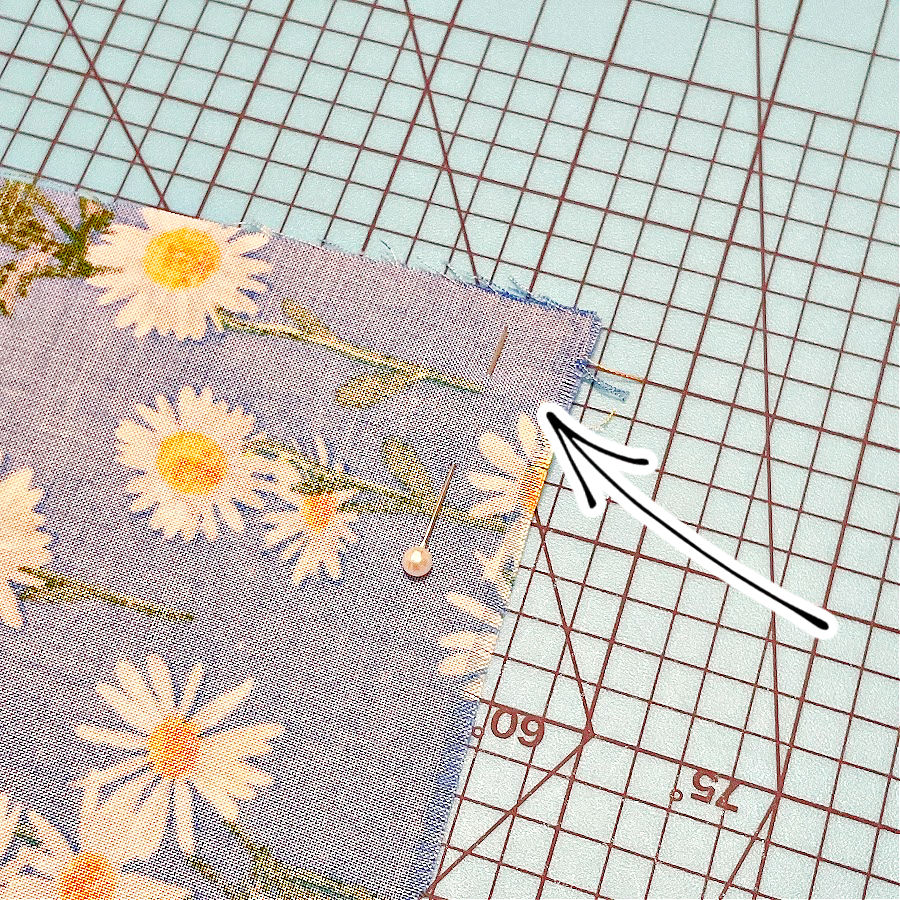 image shows a pin at the end of the future seam pinning the fabric in place and not allowing it to stretch