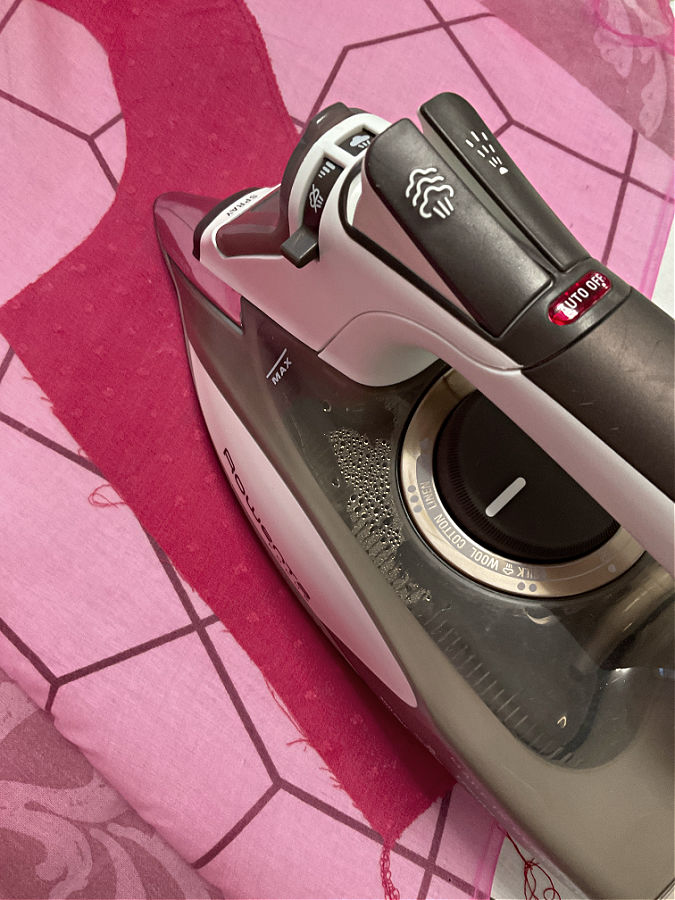 image of a sewing iron while sewing a piece of a project and using a silk organza pressing cloth