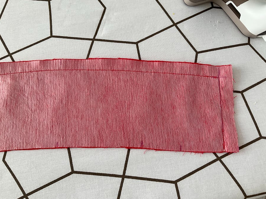 image of an unfinished collar after sewing the first seam which is not pressed yet and the piece of fabric is slightly wawy