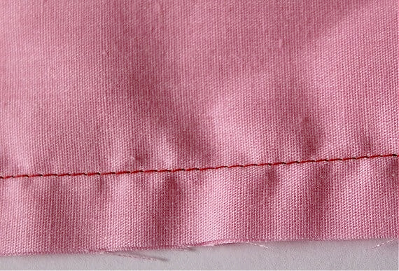 image of a seam which shows significant puckering pressing the seam in this case would be a mistake because the operation might leave permanent marks on fabric but will not fix the puckering problem