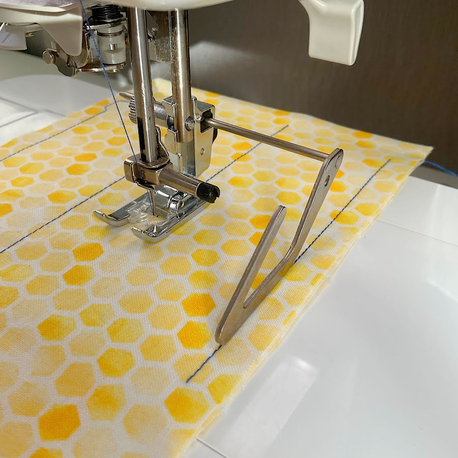 using a quilting bar as a guide for the seam while sewing