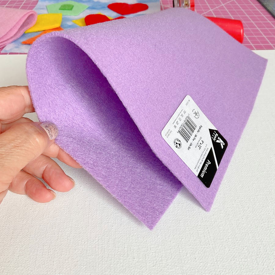 a woman's hand holding a medium stiffness piece of felt