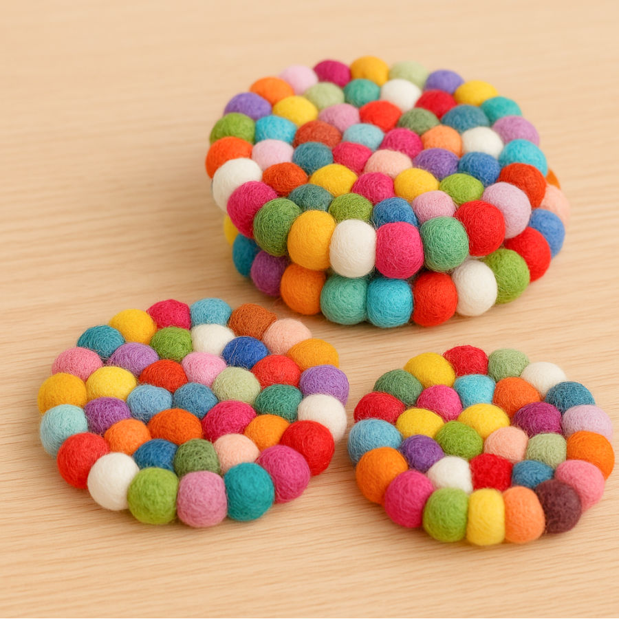 wool felt balls of various colors gathered together in circular shapes to form a coaster like structure