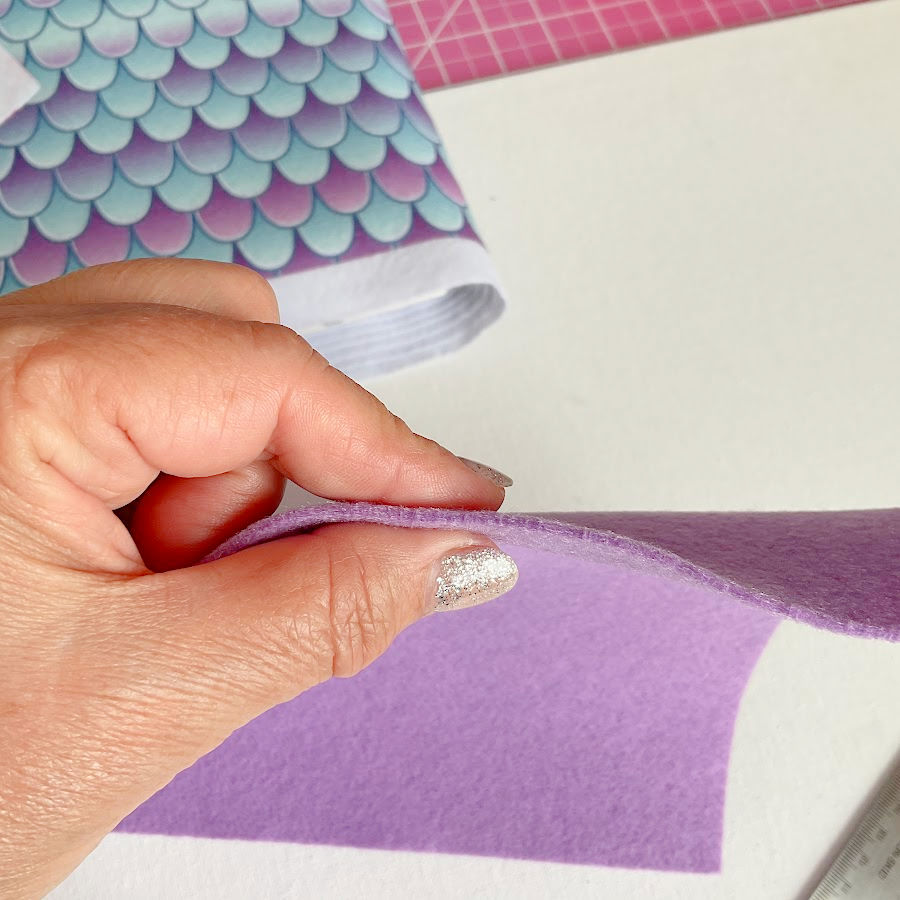 a woman's hand showingh a normal thickness piece of felt between 1mm and 2 mm