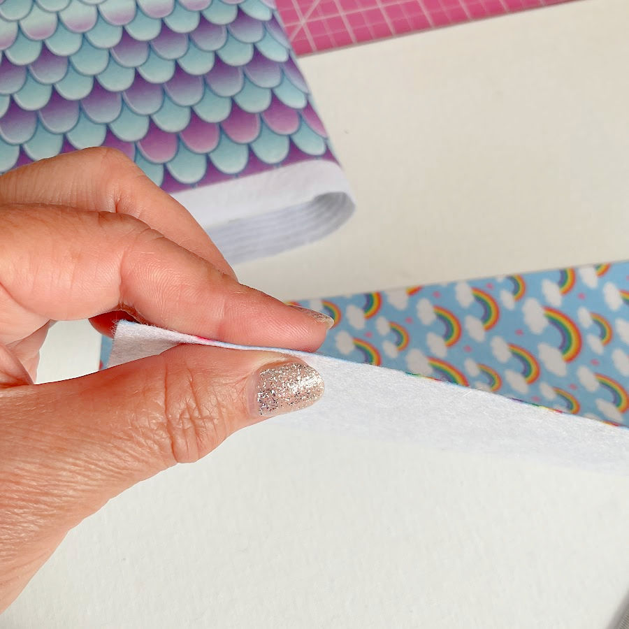 a woman's hand showing a very thin piece of felt under 1mm