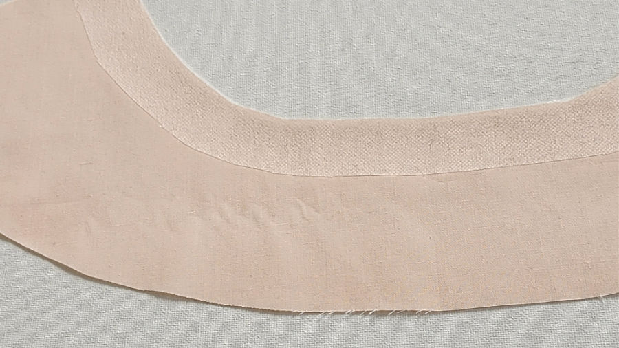 a curved neckline with light fusible interfacing knit stay tape around the edge for reinforcement