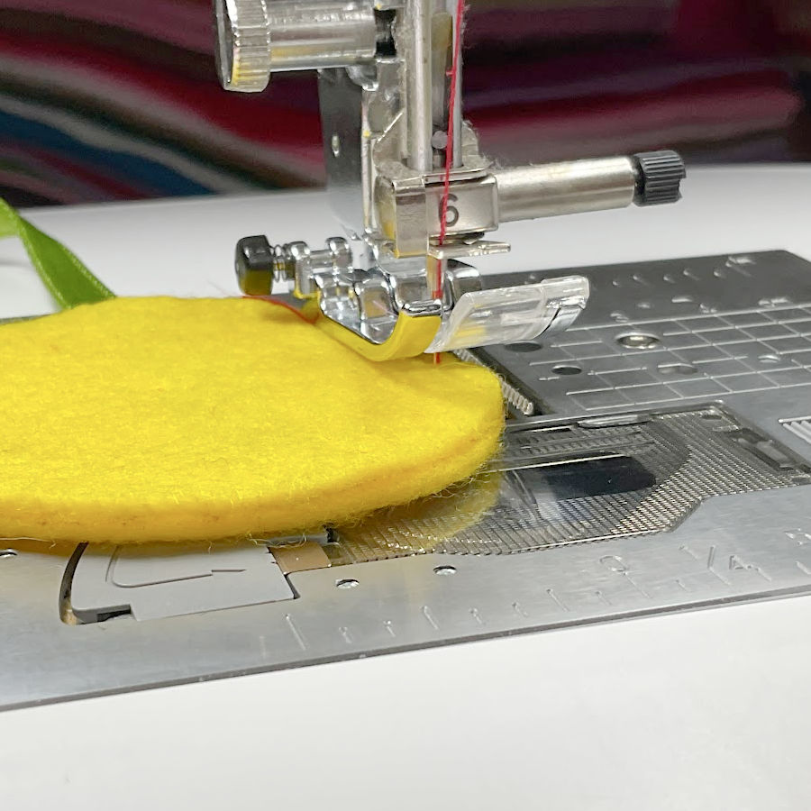 a sewing machine foot assembly sitting on a round piece of felt to exemplify the need to pivot often for following the tight curve