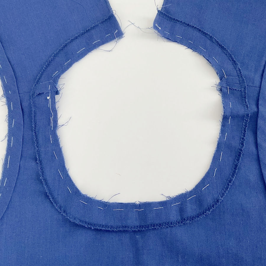 a piece of garment with a neckline showing hand basting