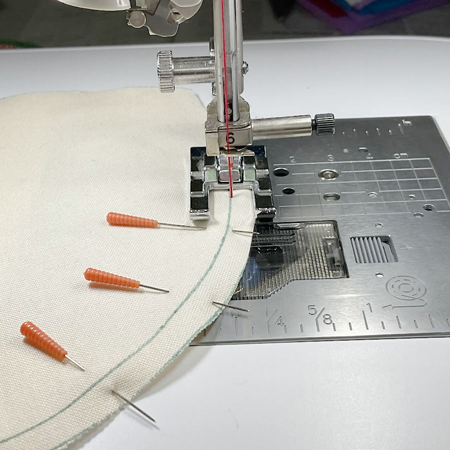 an open toe presser foot shown while sewing a curved seam to offer good visibility of the seam