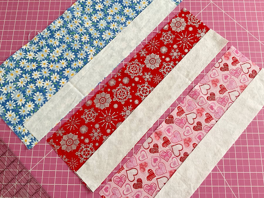 three strips of colored fabric and three strips of white fabric in preparation for step 1 of making fabric angels