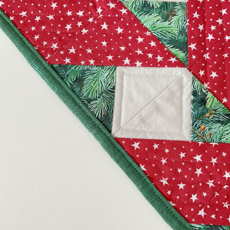 green binding used in a quilt with winter christmas motifs with both a functional and decorative purpose