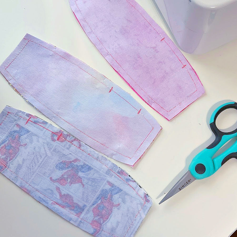 image showing the three cord keepers wrong side out after being stitched all over except the gapo required for turning a pair of small scissors is also in the image