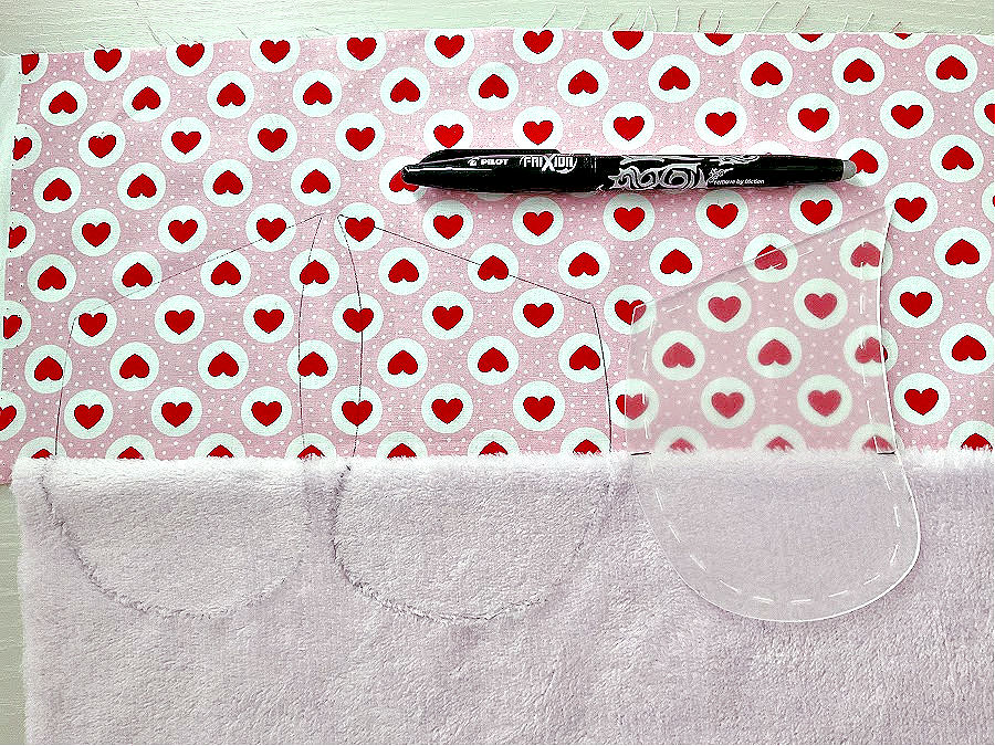 a frixion pen on a piece of fabric sewn from two separate materials with three arm pieces for the bear marked on it