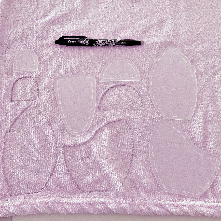 a frixion erasable pen and plastic templates used to draw on a piece of fabric prepared for cutting