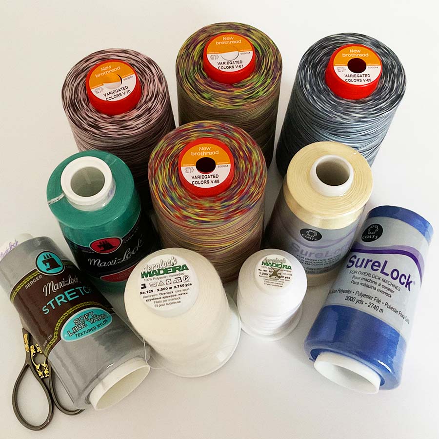 a number of cones of serger overlock thread of various colors from different manufacturers