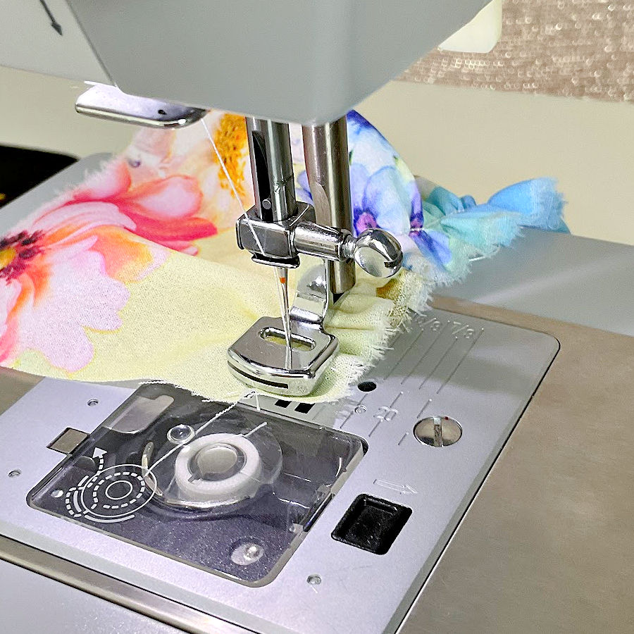 gathering foot working on a piece of multi colored polyester crepe