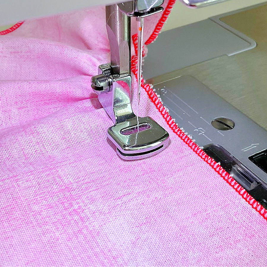 gathering foot working on a piece of pink quilting cotton