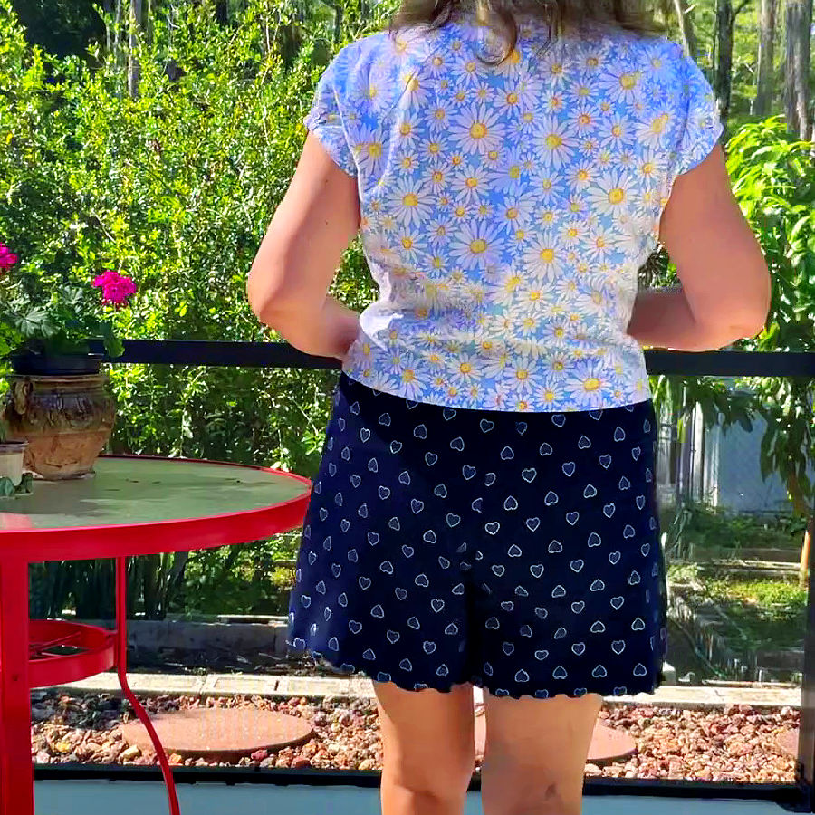 the body of a woman seen from behind wearing a pair of shorts and a blouse