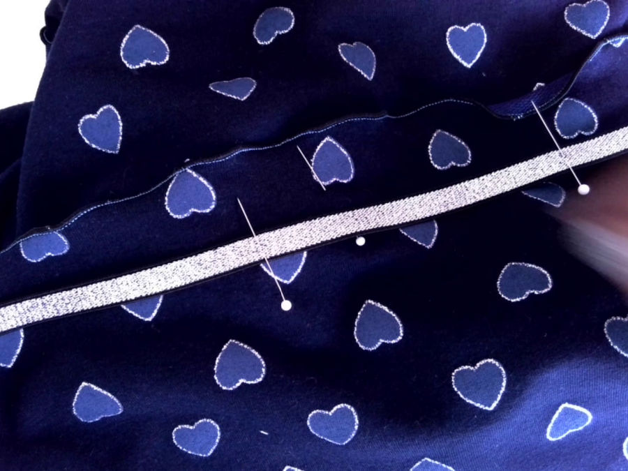 pins are marking the places where the elastic and the shorts will align while sewing