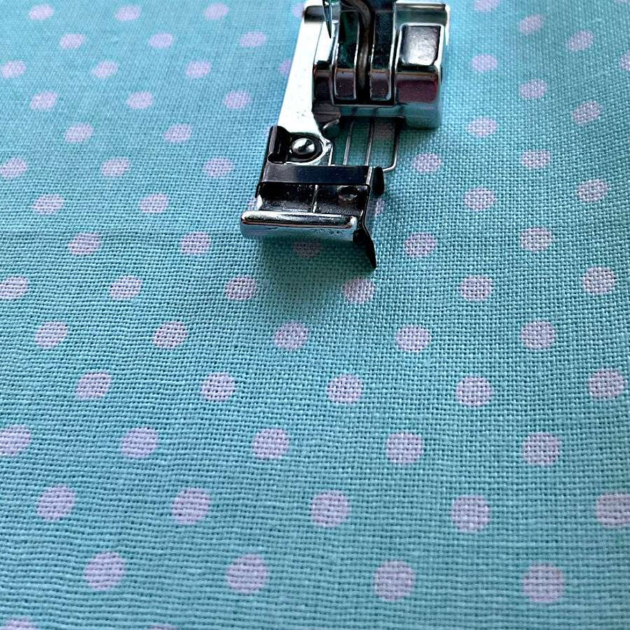 a sewing machine foot on a piece of woven fabric