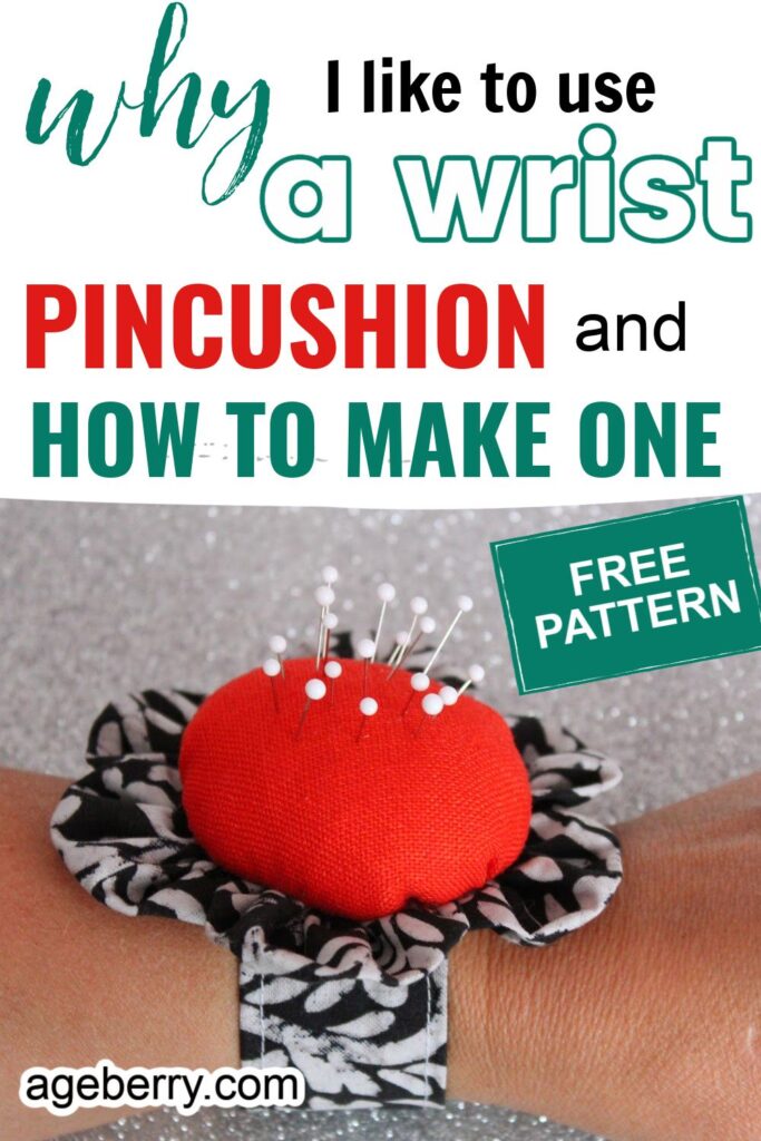 A handmade wrist pincushion bracelet shaped like a flower, featuring a red fabric center surrounded by black-and-white floral petals. The pincushion is worn on the wrist and holds several white-headed pins.