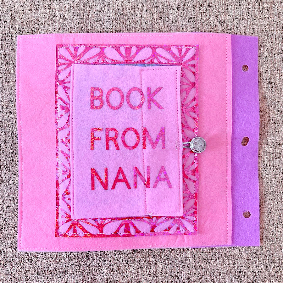 a page from the quiet book with a covered photo frame the cover is closed and the text "book from nana"