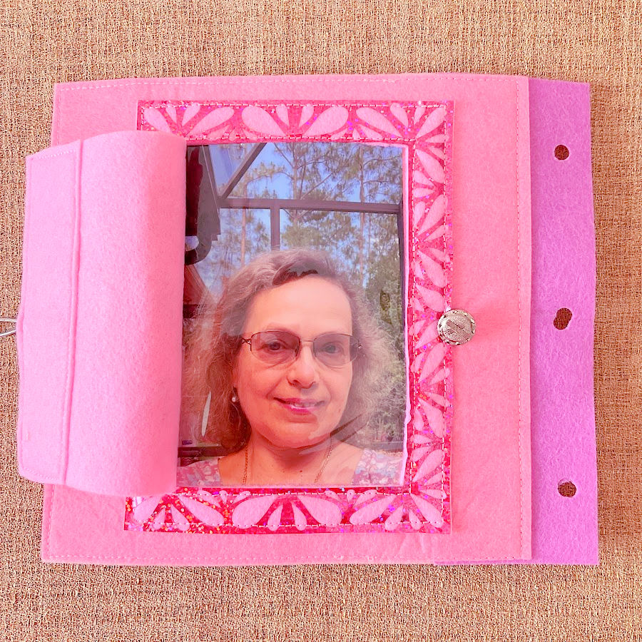 a page from the quiet book with a covered photo frame the cover is open showing the image on "nana"