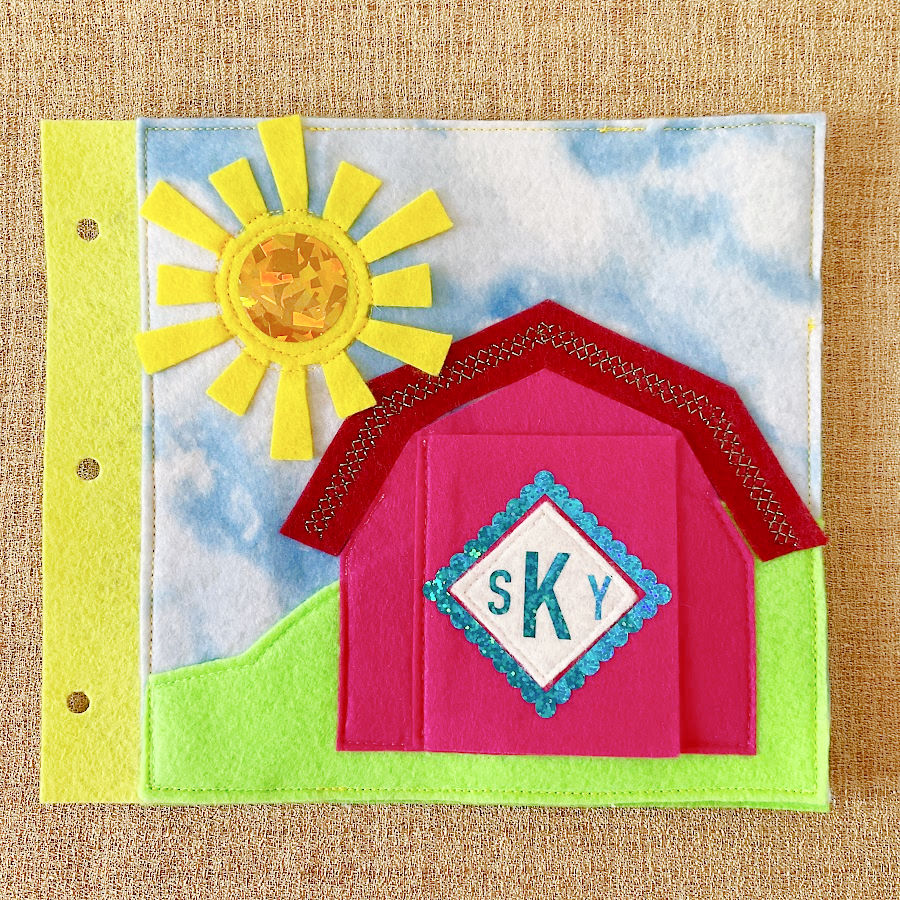 cover of the quiet book i created with the toddlers monogram on top a sun and a house