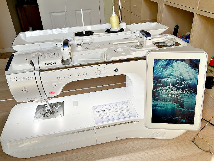 Brother luminaire sewing machine showing a large LCD touch screen display with the text "magnificent display" showing on screen