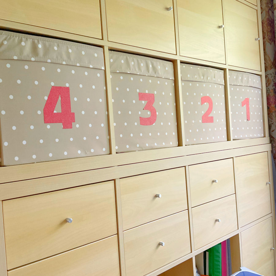 a kallax unit used as storage with boxes and drawers