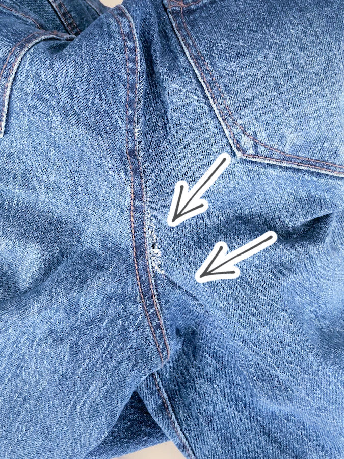 how the rip looks like after the first repair stitch two arrows point to the place where the rip is still visible but not so obvious anymore