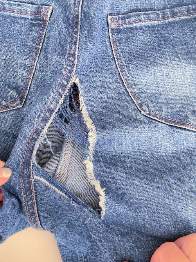 the image shows a large hole in a pair of jeans which is at a first glance not repairable