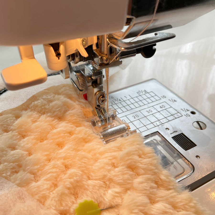 a sewing machine using the roller foot to sew the plush material
