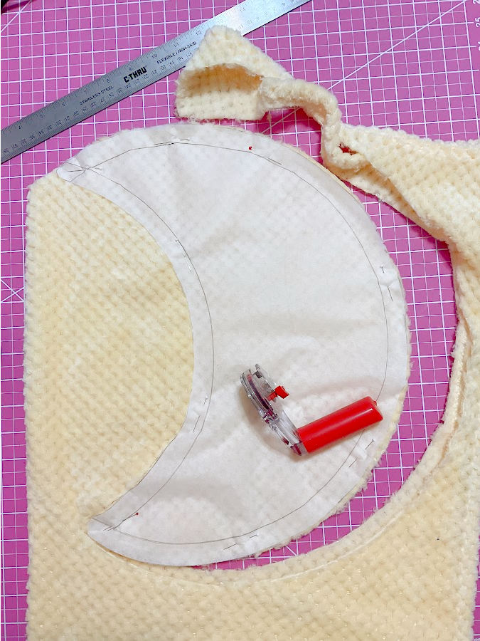 the pieces for the crescent moon plushie are cut using the pattern created at the previous step and a rotary cutter which sits on the pattern