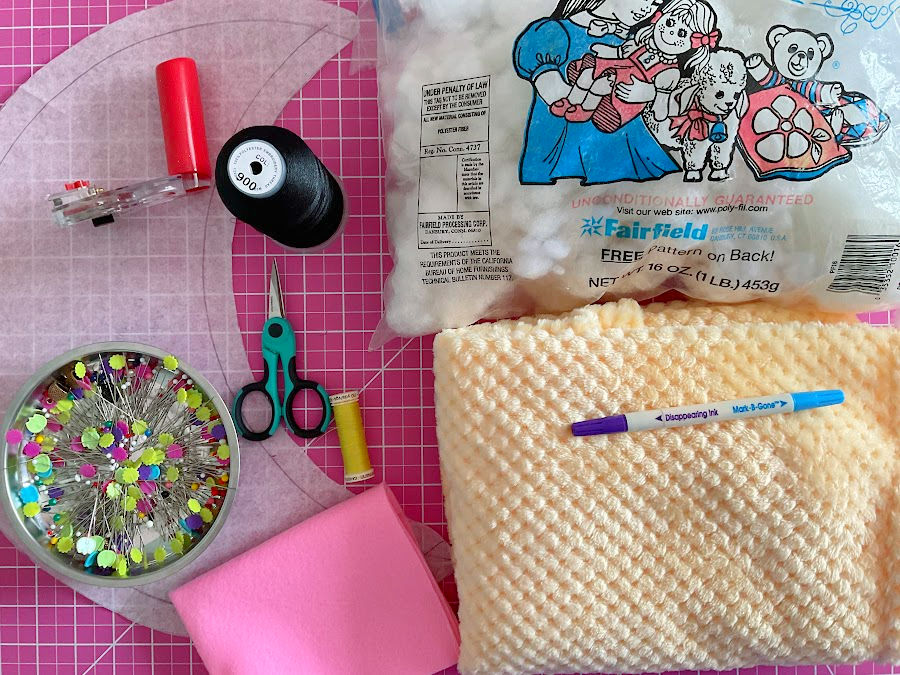 items needed for making the moon plushie gathered together interfacing fill fabric sc8issors pins thread rotary cutter