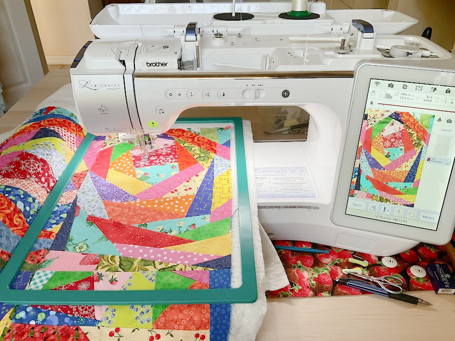 a brother luminaise sewing and embroidery machine shown while quilting a crumb quuilt sandwich framed in a magnetic frame