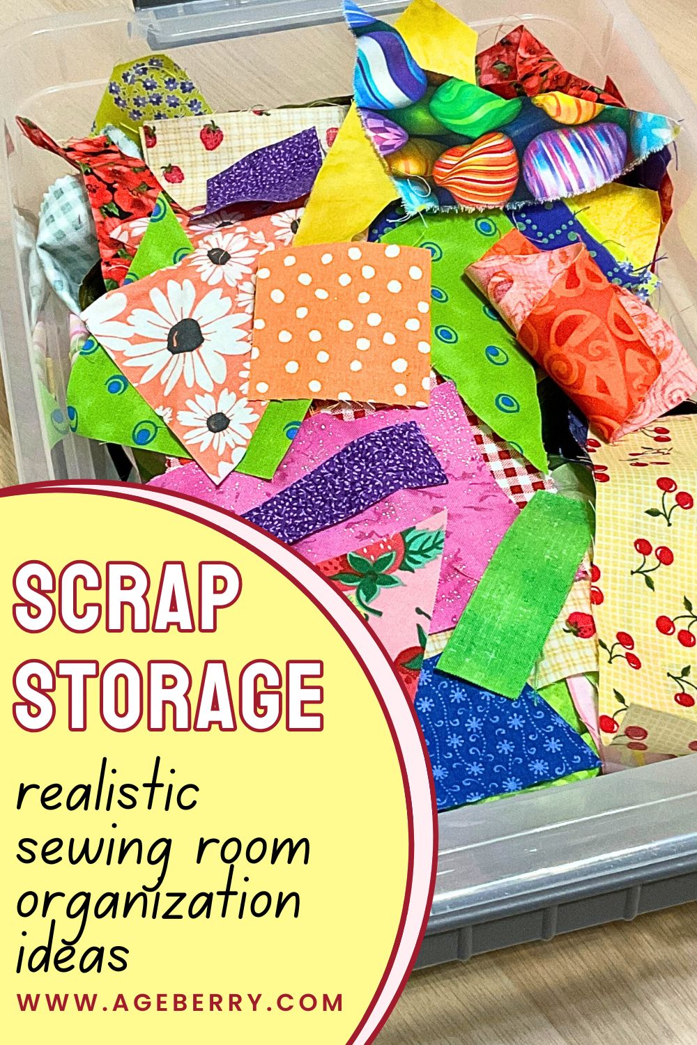 Clear plastic storage bin filled with colorful fabric scraps of various sizes and shapes, including quilting cotton pieces with floral, polka dot, novelty, and geometric prints. The scraps are loosely stacked and visible from above, showing a realistic mix of fabric remnants used for sewing and quilting projects. Text overlay reads “scrap storage realistic sewing room organization ideas” with the Ageberry website URL.