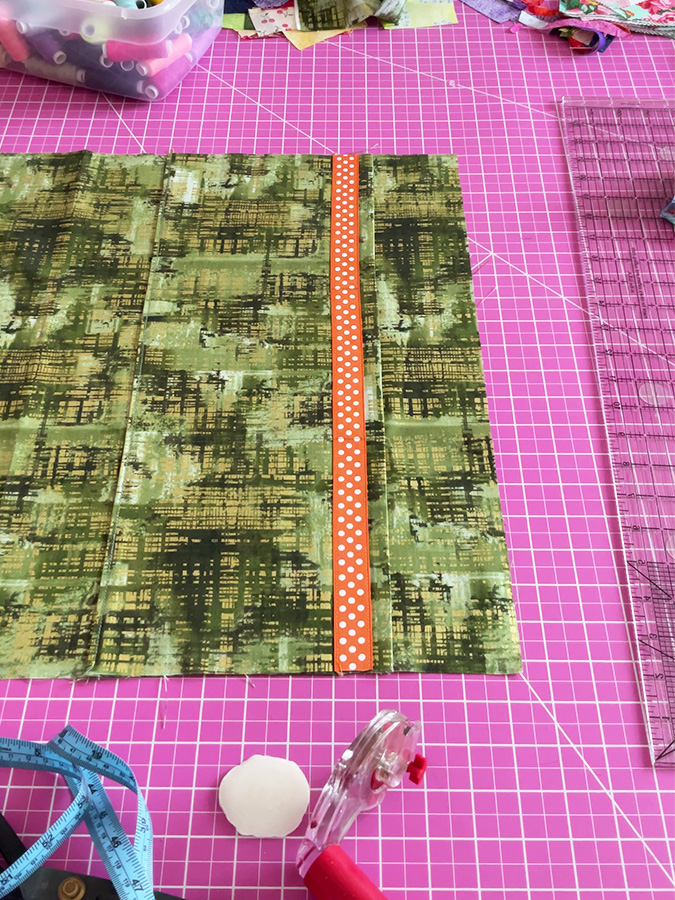 the pocket stitched to the lining on the bottom edge the bottom fold of the bag visible in the image to the left