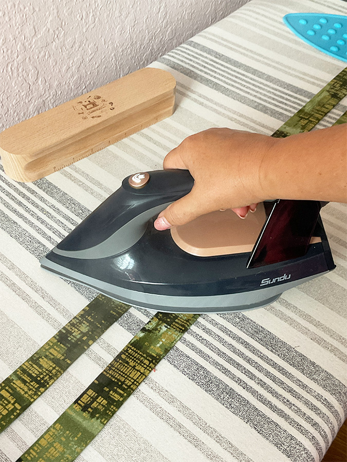 pressing the bag handles with a hot iron