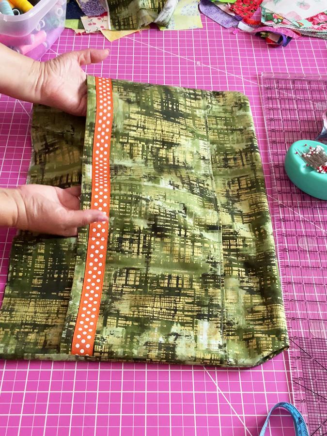 womans hands showing the pockets attached to the lining of the bag after sewing