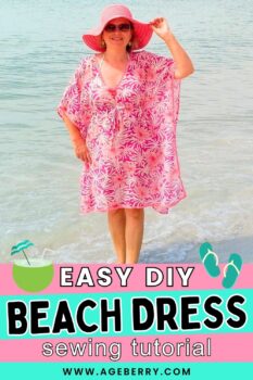 Learn how to make an easy DIY beach dress with this beginner-friendly sewing tutorial. Image shows a woman standing at the shoreline, wearing a loose pink-and-white beach dress with a V-neck, wide sleeves, and relaxed fit, paired with a pink sun hat. The simple shape and lightweight fabric make this an ideal no-pattern sewing project for summer cover-ups and vacation wear, from Ageberry.com.