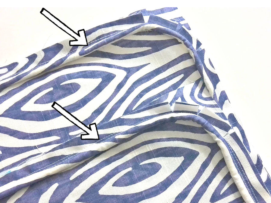 image shows the piping attached to one of the pieces of material in the project an arrow highlights the seam that was done close to the original seam for the pipinb itself