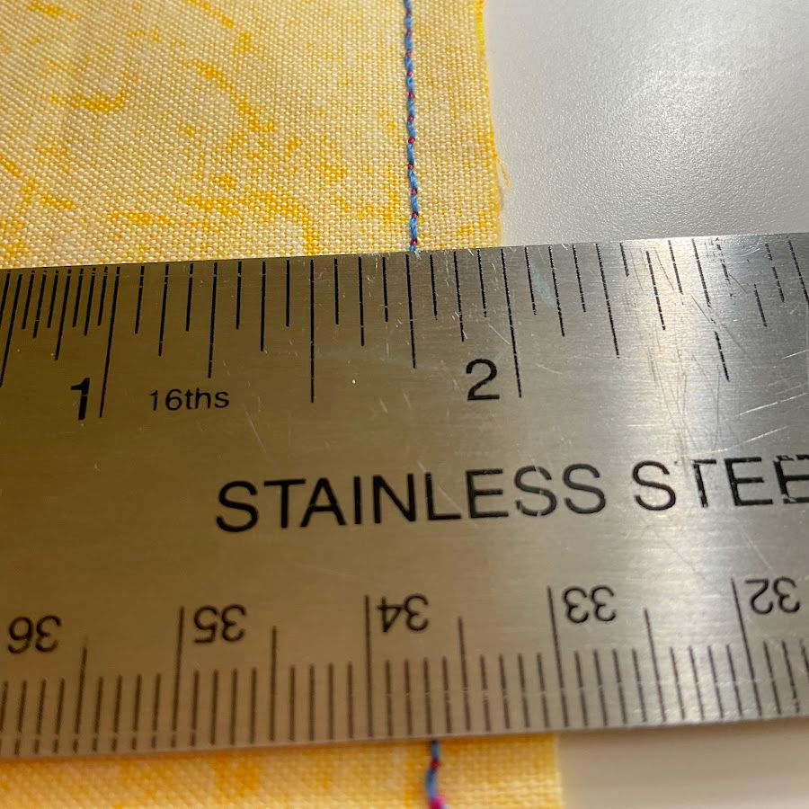 s ruler shown measuring a scant quarter inch seam and the seam shows a very small amount smaller than a quarter inch