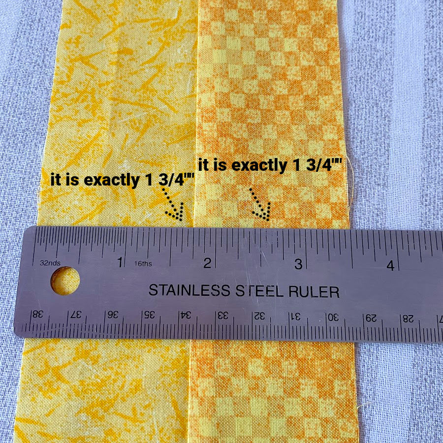 a ruler on top of fabric showing two seams sewn 1 3/4 inch and 1 3/4 inch from the edge of the fabric which are exactly of that dimension