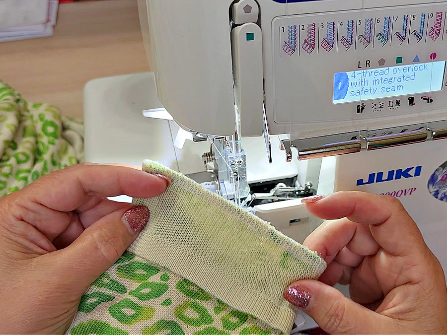a womans hands shown while inspecting the quality of the final stitch on the shortened sleeve