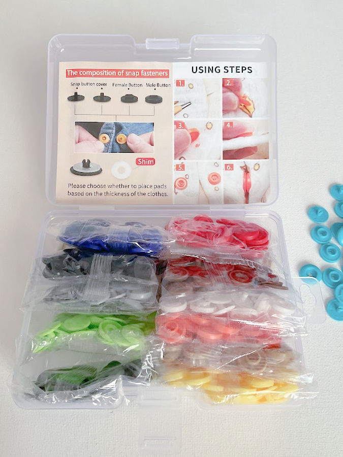 the original package of snaps the packets of colored snaps visible unopened and the printed instructions also seen in the box