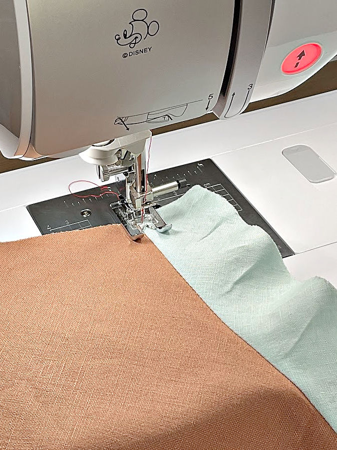 the needle assembly of a sewing machine shown at the beginning of the understitching seam