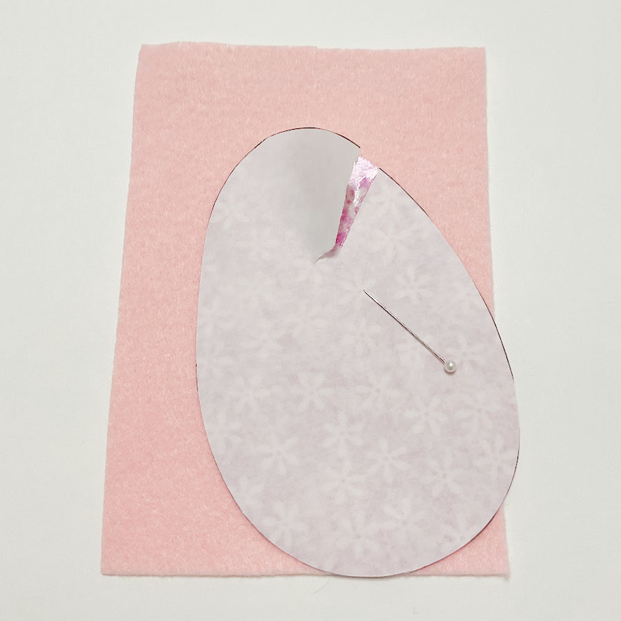 the beginning of a tear shown on the paper backing of the egg shape a pin used to scratch anbd start the tear shown in the image also