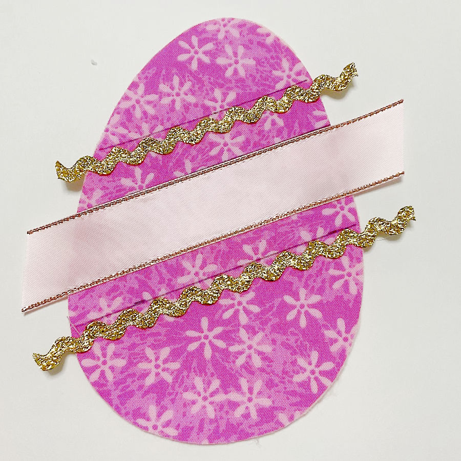 all three pieces of ribbon attached to ther face of the egg in the proper positions